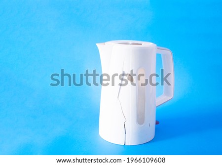Broken electric white kettle on colored background 