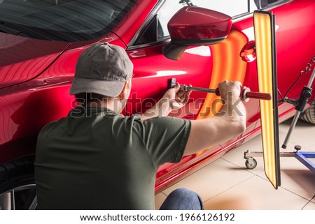 removal of dents without painting. PDR technology for car body repair Royalty-Free Stock Photo #1966126192