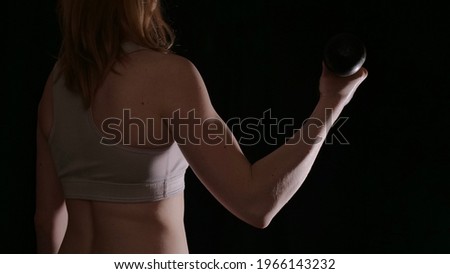 Woman back in sportswear during workout in a pose on a black isolated background without a face. The image shows female muscles and a healthy beautiful body