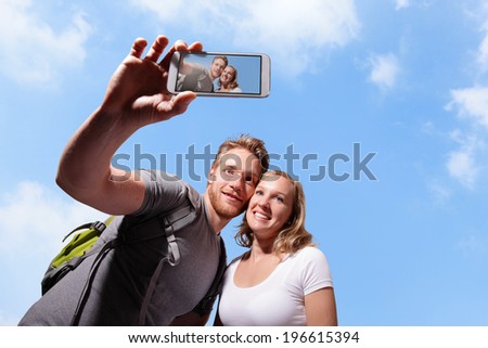 happy couple selfie by smart phone with sky background, caucasian