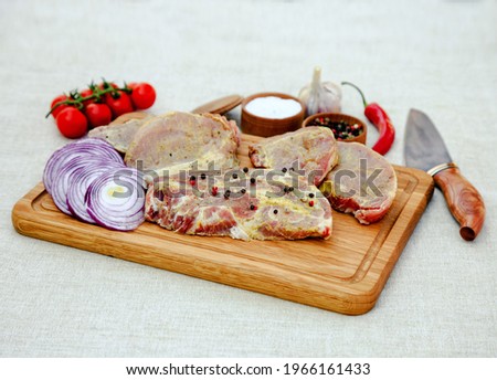 Appetizing steak on a wooden board. Cherry tomatoes, onions, peppers and steak for an unsurpassed dish