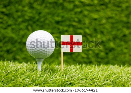 Golf ball with England flag is on green grass