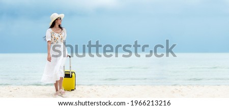 Summer vacations. Lifestyle woman relax and chill on beach.  Asian happy young people wearing white dress fashion and holding suitcase  in summer trips enjoy  tropical beach, copy space for banner