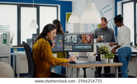 Video editor and sound engineer working togenther at project, editing audio and film footage in post production software. Women videographers processing movie montage sitting in creative agency office