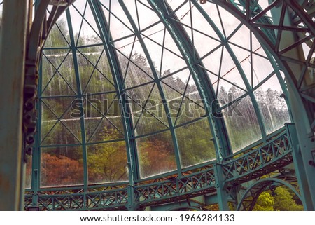 Transparent dome on steel trusses. Raindrops on the glass dome of an old abandoned building