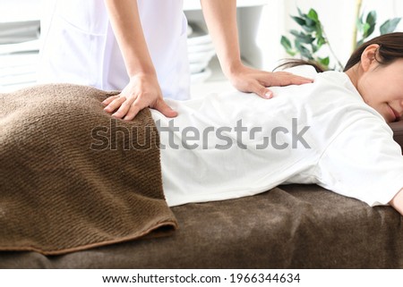 Image of a young woman receiving a surgical massage Royalty-Free Stock Photo #1966344634