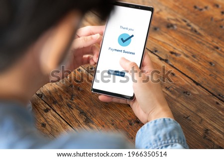 A woman's hand using mobile application on her smartphone to do online transaction for her order. Payment, Internet banking, Paid, Confirm, Secure, Website, Shopping, Smart living, Internet technology Royalty-Free Stock Photo #1966350514