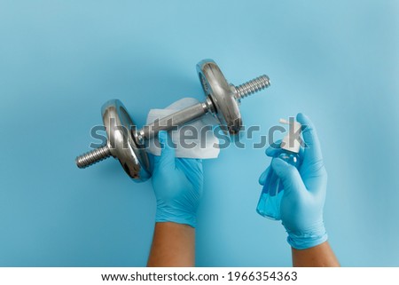 Fitness cleaning gym  Covid 19 virus using  alcohol spray anti virus concept Workout from home stay safe Royalty-Free Stock Photo #1966354363