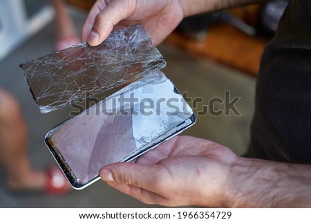 a man holding a broken smartphone in his hands