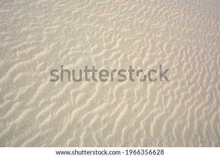 Light golden sand texture background with rippled surface pattern waved by wind