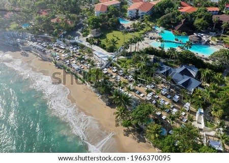 An aerial shot of beach surrounded by a resort area and sea under the sunlight