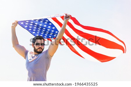 proud strong american man  waving USA united state  flag against blue sky
