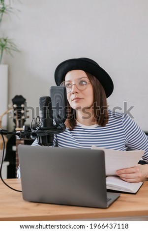 podcast, audio content creation. a beautiful European woman podcaster or radio host records a podcast or content in a recording studio