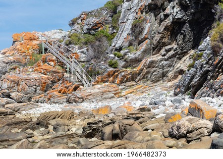 Rocky shoreline with wooden stairs in the background. This is part of the Otter trail in Tsitsikamma National Park in South Africa