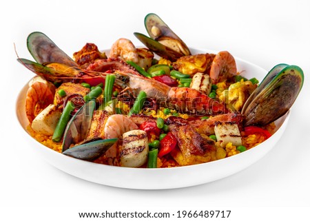 Paella. Spanish dish of rice and seafood, vegetables and chicken. Shrimp, octopus, crab and mussels. Banquet festive dishes. Gourmet restaurant menu. White background.
