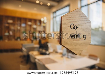 Co-working sign board on glass in foreground. Newly opened space for co-working.