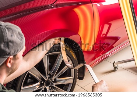 Removing dents on the car. PDR technology. Car body repair without painting. Royalty-Free Stock Photo #1966565305
