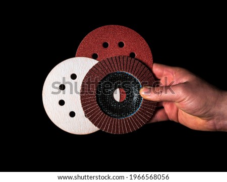 Builder hand keeps or gives abrasive tools close up on isolated black background. The idea of starting a successful work. Free advertising space. Royalty-Free Stock Photo #1966568056