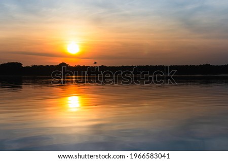 the setting sun over the Masurian Lake in Poland. Sunset over the water.