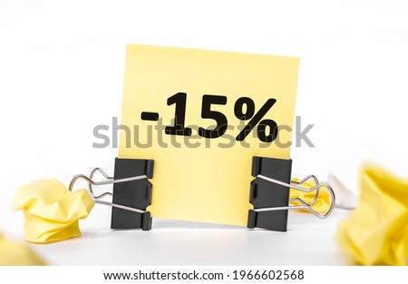 minus 15 percent inscription on a yellow piece of paper for notes. Stationery Paper clips, crumpled paper. financial business concept. sale, discounts.