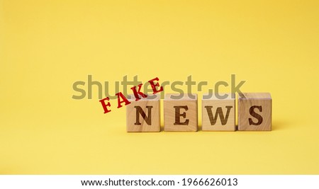 wooden cubes with the inscription false news on a yellow background. The concept of information hygiene, propaganda, debunking of myths and false information. Influence of the media on public opinion Royalty-Free Stock Photo #1966626013