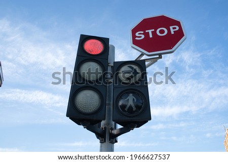 traffic light and traffic sign viewed from below with sky and clouds in the background. view