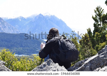 Photographer or traveler  taking pictures of a beautiful forest and mountain river landscape