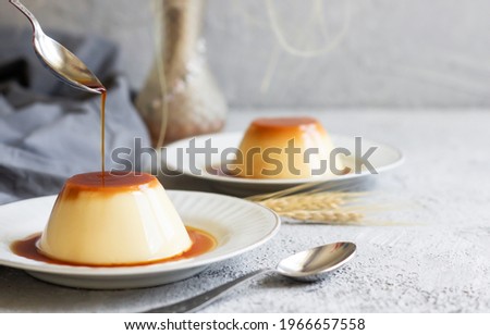 Cream caramel pudding with caramel sauce in plate on white rustic table Royalty-Free Stock Photo #1966657558