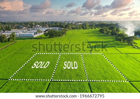 Land for sale and investment in aerial view. Include green field, agriculture farm, residential house building, village. That real estate or property. Plot of land lot for subdivision or development. Royalty-Free Stock Photo #1966672795