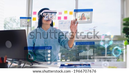 asian woman using augmented reality (ar) and Mixed reality glasses simulation meeting and working with hologram over table at office.virtual reality development process concept