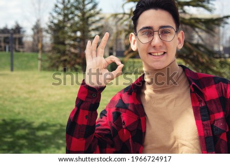 A young serious man points with hand gestures. Unique offer, promotion and discounts. Place for your text.