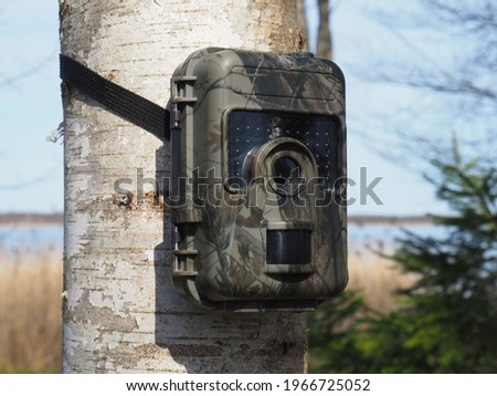 Outdoor wildlife surveillance camera with motion detector. Hunting trail camera.