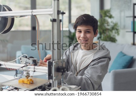 Smart young boy learning how to use a 3D printer at home, science and technology concept