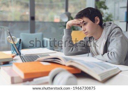 Tired student taking online classes, he is confused and staring at the computer screen