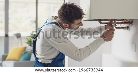 Professional plumber checking a boiler and pipes, boiler service concept Royalty-Free Stock Photo #1966733944