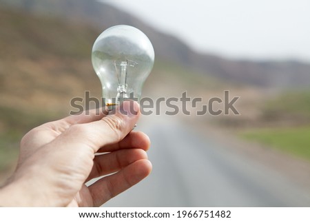 holding a lamp on the background of nature during the day
