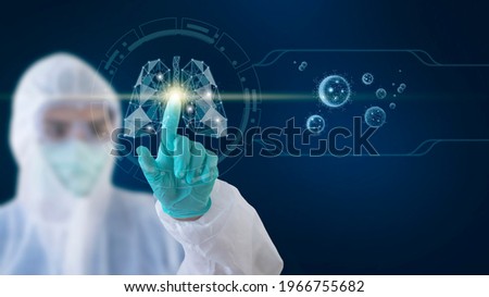 A doctor wearing a ppe gown touches a lung shape on a touchscreen. With a picture of the coronavirus on the side, healthy and technology concept