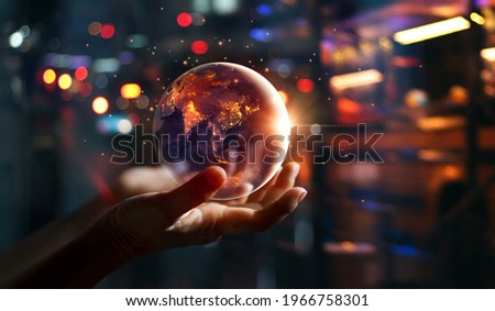 Earth at night was holding in hands on night city background , Energy saving, Earth day, Elements of this image furnished by NASA. Royalty-Free Stock Photo #1966758301