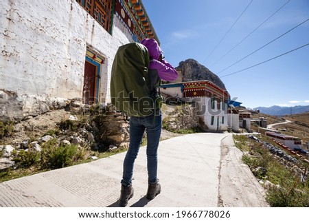 Woman hiker taking photo in tibet,China