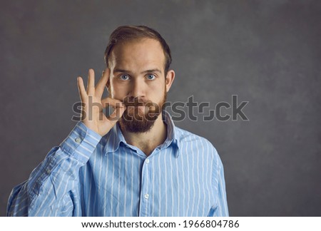 Headshot of confident handsome young caucasian guy showing secret silent gesture asking stop talking keep silence asking be quiet. People emotion and expression face portrait and confidentiality Royalty-Free Stock Photo #1966804786