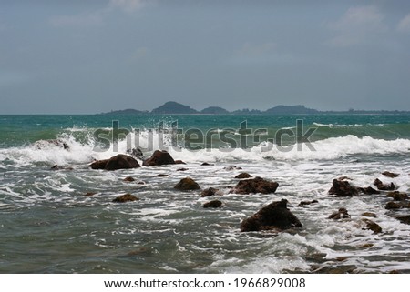 The scenery of rocks in the sea with white waves and not clear sky from south of Thailand.