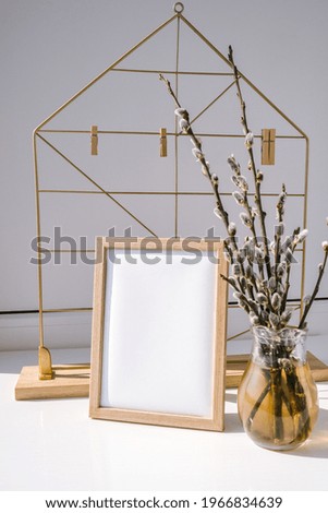 Mock up interior Picture frame with Willow branch in glass vase. Brunch of the blossoming pussywillow on early spring. Easter spring still life