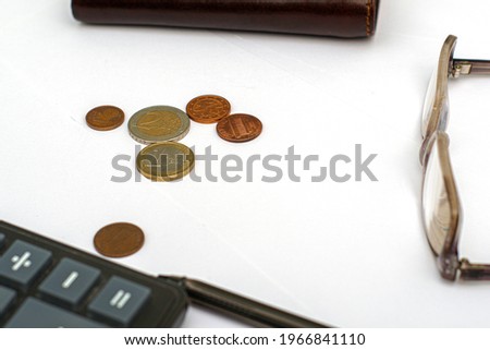 wallet calculator glasses fountain pen and small coins on white sheets of paper on the table concept budget economy finance. High quality photo