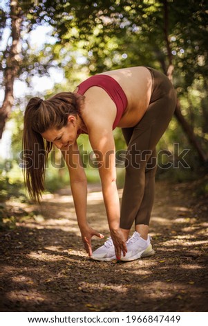 Pregnant woman working exercise in the forest. 