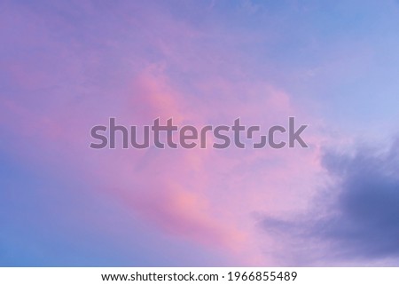 Picture of blue sky, purple pink, and white and gray clouds.