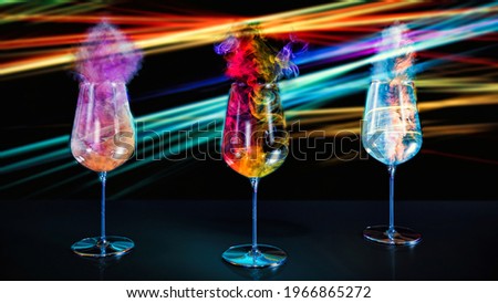 Creative concept of  urban, futuristic party with neon lights and glasses full of colorful cocktails that is like smoke. Cyber partying on black background.