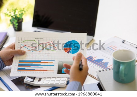Businessman hands hold documents with financial statistic stock photo,discussion and report analysis data the charts and graphs. Finance concept