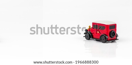 Miniature toy red retro car on white background. Metal model.,A red toy car on a white background