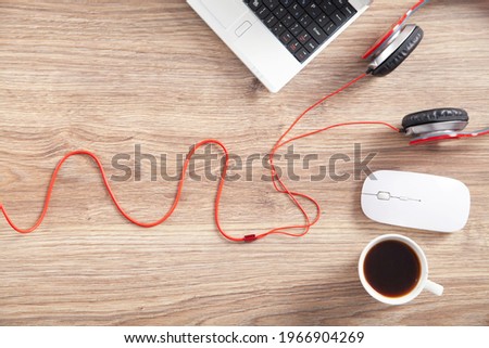Red headphones, coffee, computer keyboard and mouse.