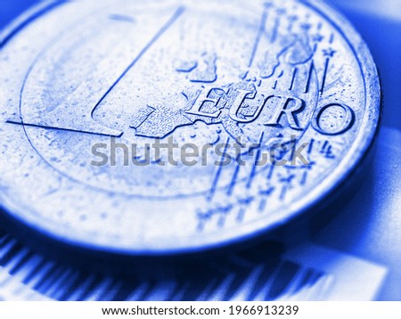 1 one euro coin close-up. The name of the Eurozone currency in focus. Light blue tinted background. Bright backdrop about economy and finance of the European Union. Macro Royalty-Free Stock Photo #1966913239